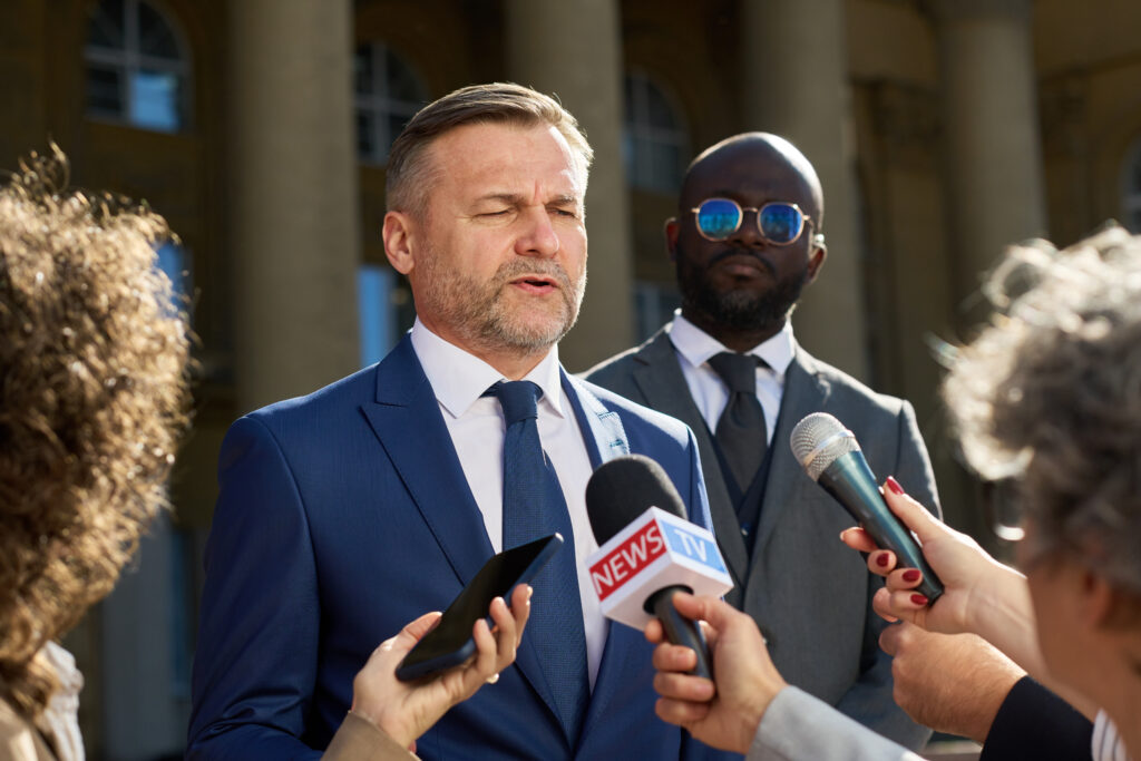 man-in-suit-speaks-to-press-microphones-2026-01-11-08-29-37-utc